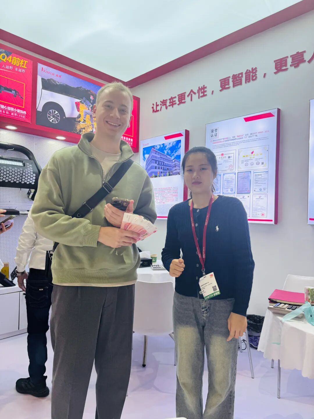 Overseas visitor talking with a WINFOR representative in front of the booth at Automechanika Shanghai 2024