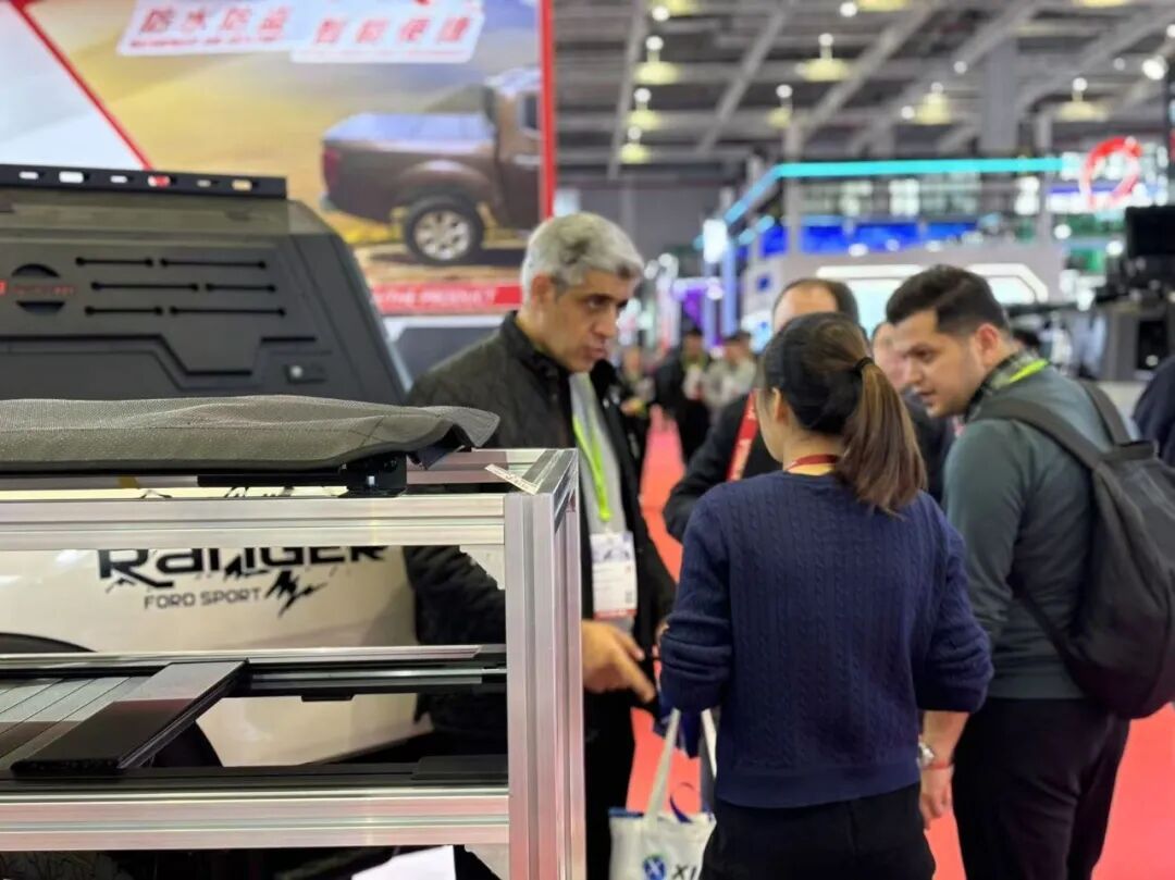 Buyers stopping for a conversation with staff in front of the WINFOR stand on the Automechanika Shanghai 2024 show floor