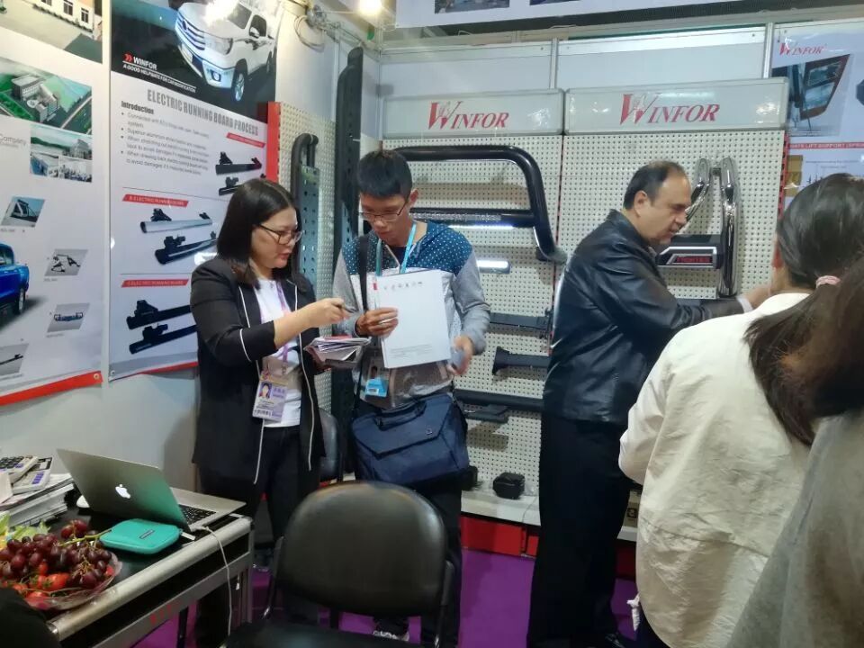 Customer being received by WINFOR staff at the trade show stand, discussing ODM customised tailgate buffer and tonneau cover solutions
