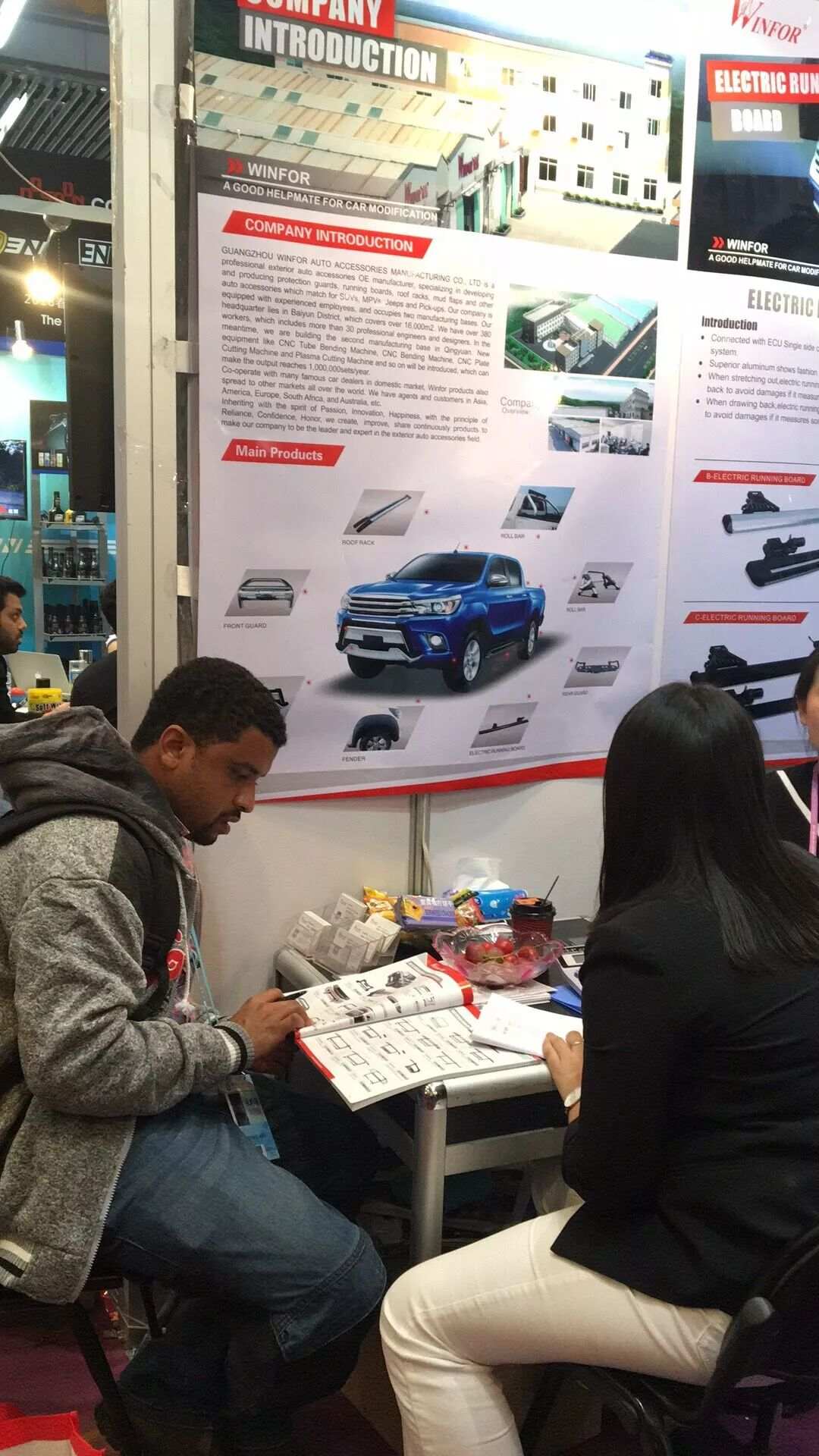 WINFOR display board of pickup tonneau covers at the Canton Fair, buyers examining samples and discussing ODM customisation