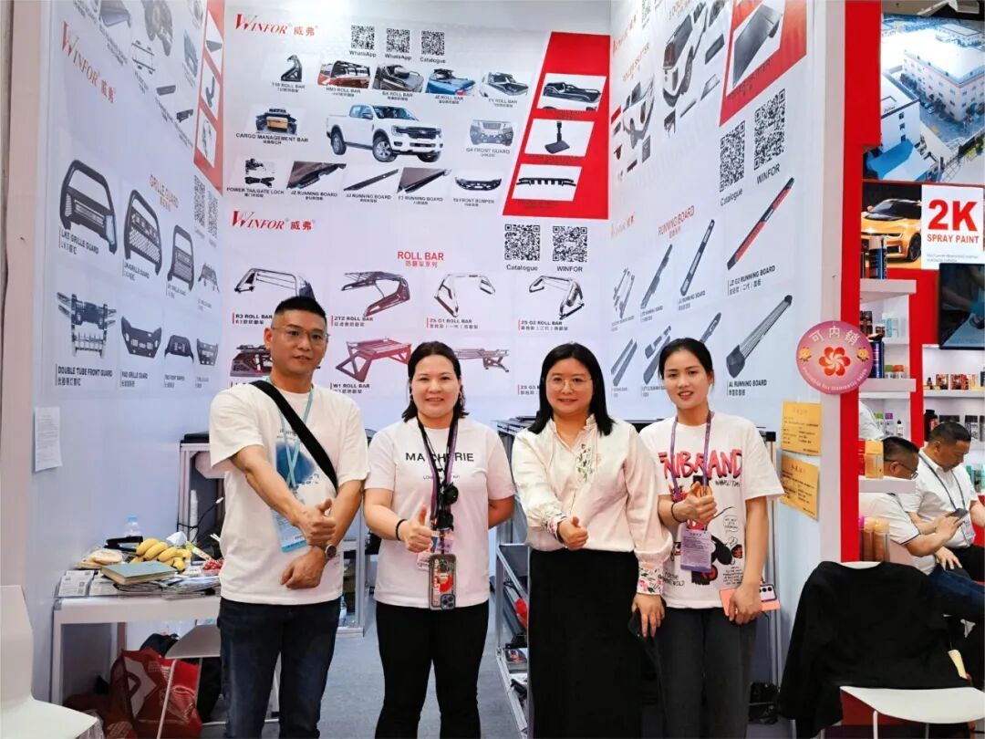 WINFOR booth team posing with an overseas customer at the 135th Canton Fair in 2024, in front of the pickup bed accessory display wall