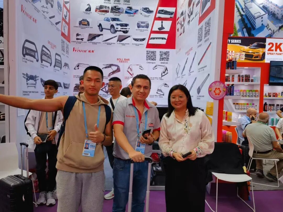 WINFOR team and a customer smiling for a photo in front of the booth at the 135th Canton Fair