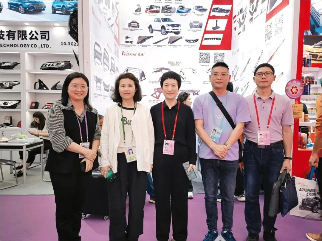 Four WINFOR staff members and a customer posing together in front of the booth at the 135th Canton Fair