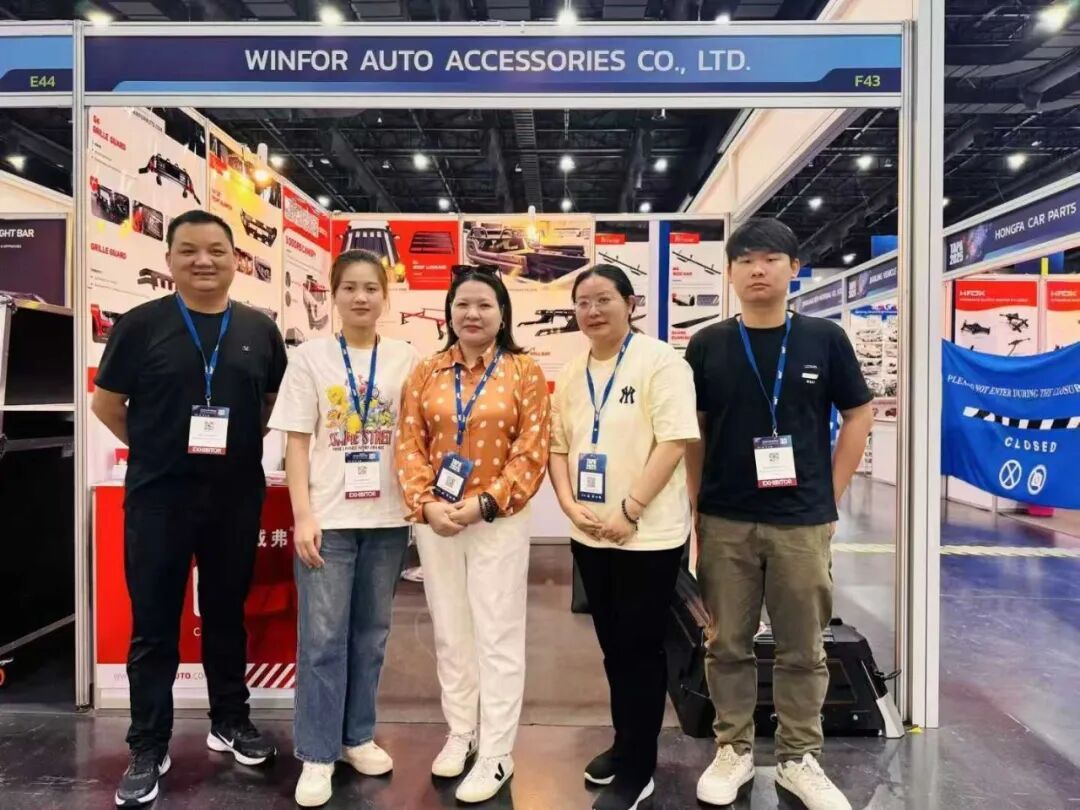 Four WINFOR team members posing in front of the WINFOR stand at TAPA 2025 in Bangkok